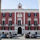 Di fronte al politeama si staglia invece l�imponente Palazzo della Prefettura, di severo stile neoclassico. Progettato dopo che nel 1806 Bari �strapp� a Trani il titolo di capoluogo di provincia, si presenta con un prospetto di colore bianco e rosso, scandito da finestre timpanate e coronato da un cornicione al centro del quale si eleva la particolare torretta dell�orologio